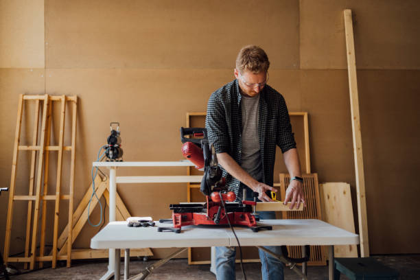 istock Carpenter Making Measurements and Drawing on a Plank at his Workshop 1331350671