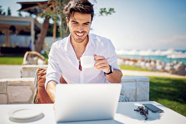 istock Young businessman is working and drinking coffee on the beach 1331350714