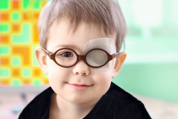 istock A little boy wearing glasses and an eye patch (plaster, occluder) 1331359287