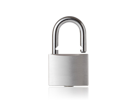 An unlocked gold padlock with a key lies isolated on a white background with space for text closeup