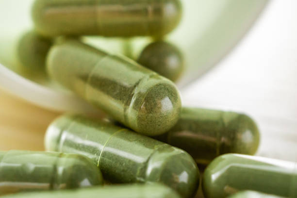 istock Herbal medicine capsules with bottle on wood table 1331365403