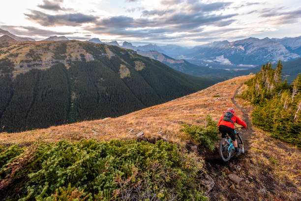 istock Mountain biker follows trail down mountain ridge 1331365933