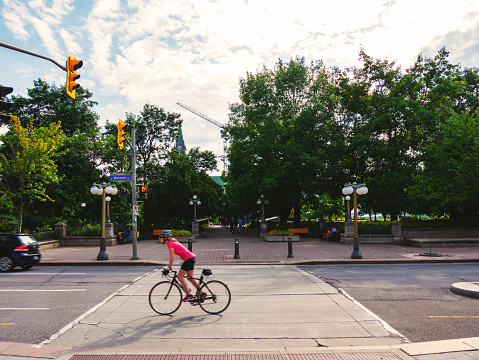 Ottawa, Ontario, Canada. July 2021. Woman riding a bicycle on Mackenzie Street, Ottawa.