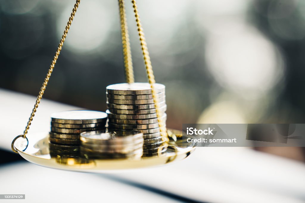 Coins stack with balance scale. Money management, financial plan, time value of money, business idea and Creative ideas for saving money concept. Currency Stock Photo