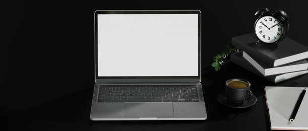 istock Dark office work space with open laptop mockup on black table background 1331381994