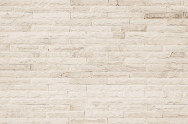 istock Empty Background of wide cream brick wall texture. Old brown brick wall concrete or stone pattern nature, wallpaper limestone abstract floor/Grid uneven interior rock. Home & office design backdrop. 1331386119