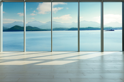 Through the floor-to-ceiling glass windows, overlooking the mountains in the distance