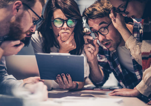 istock Team of nerdy entrepreneurs reading confusing reports in the office. 1331396043