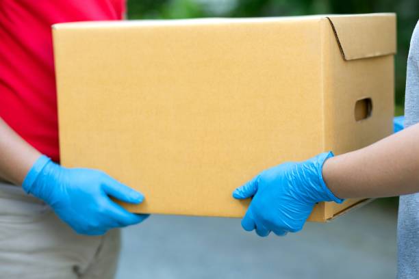 istock Male courier delivering parcels to customers 1331398184