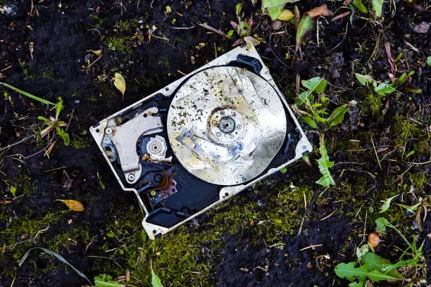 Crushed Hard Disk Drive on the Dirty Ground closeup