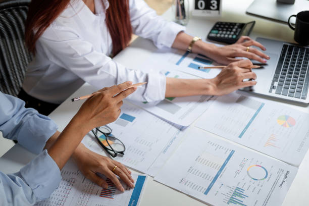 istock Two colleagues discussing with document data and calculator on desk table. Close up business team analysis and strategy concept 1331404611