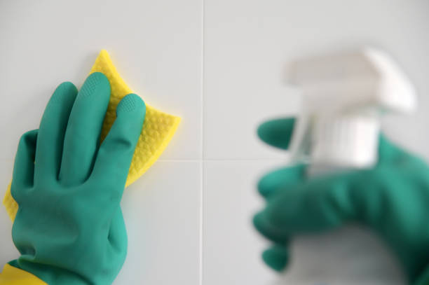 istock Person wearing protective plastic gloves clean bathroom tails with cleaning material and a sponge 1331411239