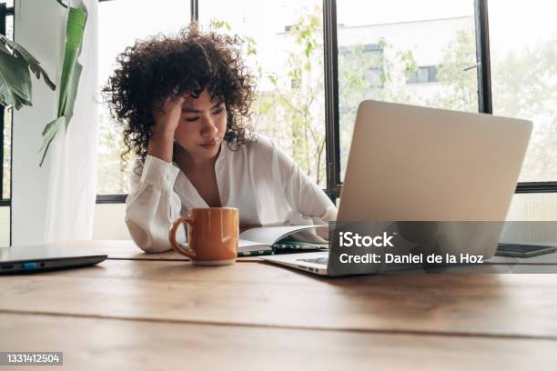 Young African American Woman Tired Exhausted From Working Studying Hard Bored And Frustrated Looking At Laptop Head Resting On Hand Bright Space Big Windows Stock Photo - Download Image Now