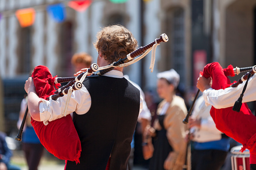 Morlaix, France - July 18 2021: Two Breton musicians in traditional costume playing bagpipes.