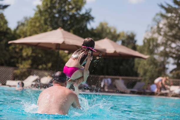 istock Girl jumping into water from father's shoulders 1331425408