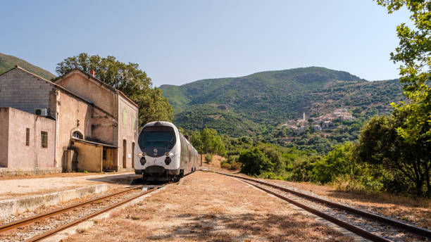 Palasca, Corsica, France - 28th July 2021: A train passes through the derelict station at Palasca in the Balagne region of Corsica