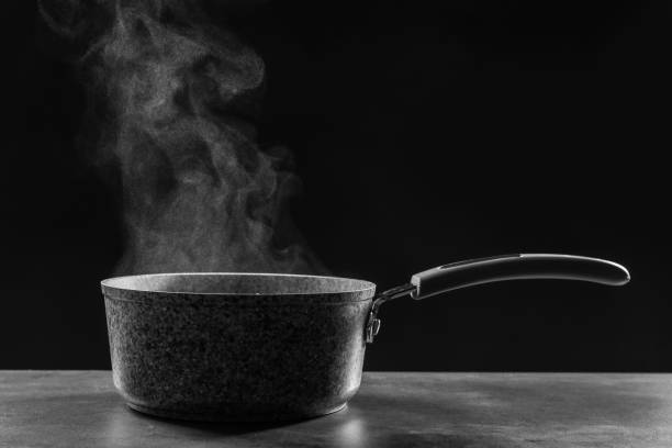 istock Steaming saucepan on grey table against dark background 1331427914