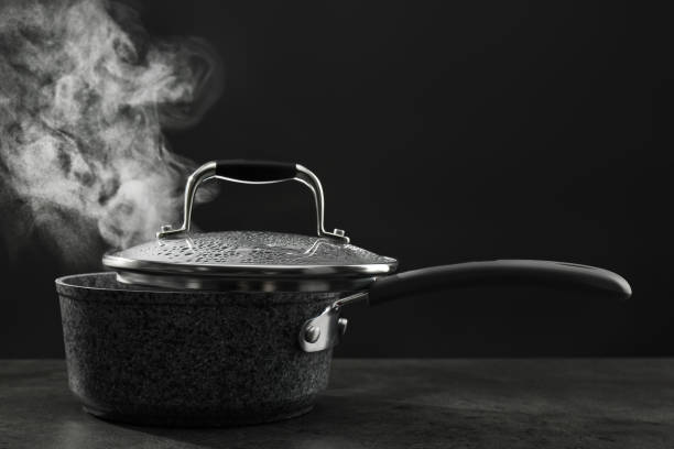 istock Steaming saucepan on grey table against dark background 1331428668