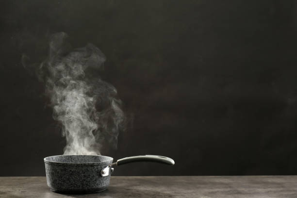 istock Steaming saucepan on grey table against dark background 1331429286