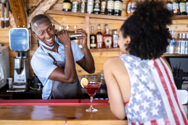 istock Afro-American bartender with a face shield preparing cocktails in his bar during coronavirus conditions 1331431116