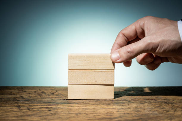 istock businessman holding blank wooden block for creating conceptual creative structure. mockup for business chart template. blue background. project illustrative layout 1331432698