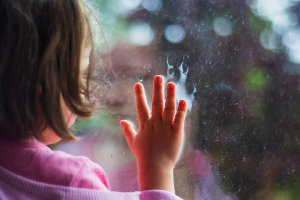 istock little girl looking out the window 1331433678