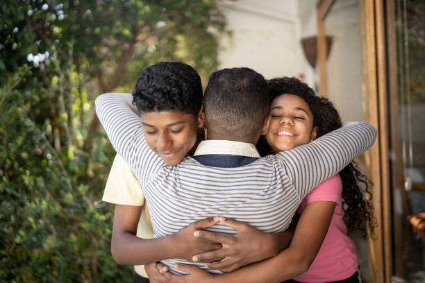 istock Father embracing son and daughter at home 1331433883
