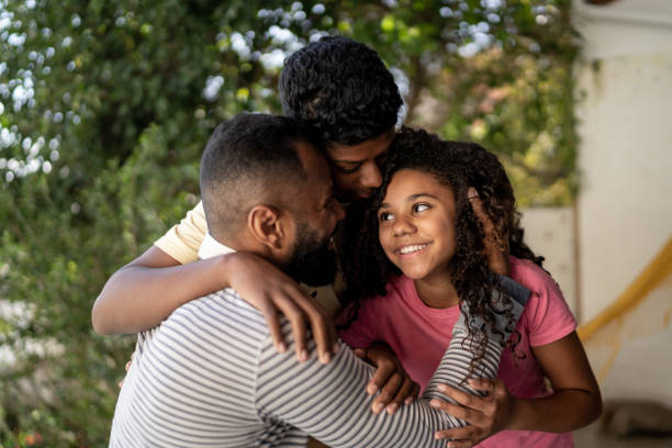 istock Father embracing son and daughter at home 1331433884