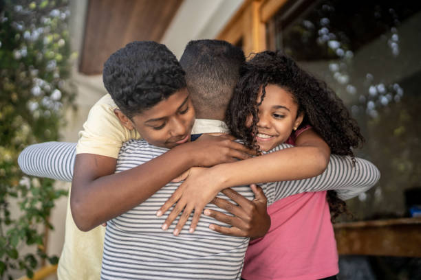 istock Father embracing son and daughter at home 1331433886