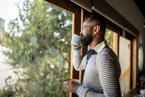 Hombre maduro bebiendo té y contemplando en casa photo