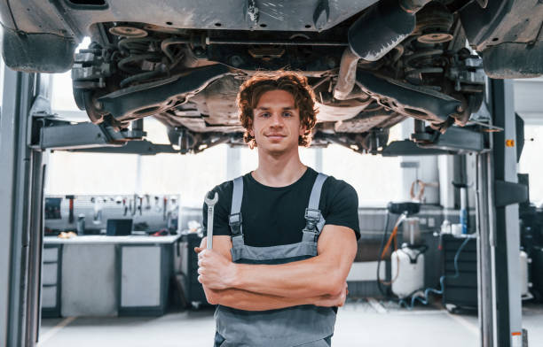 istock Handsome adult man in grey colored uniform standing below automobile 1331439061