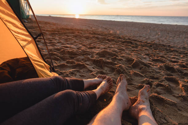 istock couple sitting on sandy beach looking on sunset 1331439397