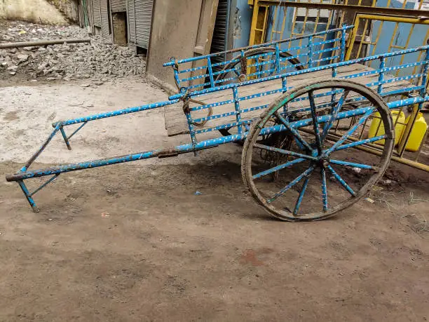 Stock photo of sky blue color old rusty bullock cart or hand cart parked outside of the go-down at Gandhinagar market area ,Kolhapur Maharashtra India.