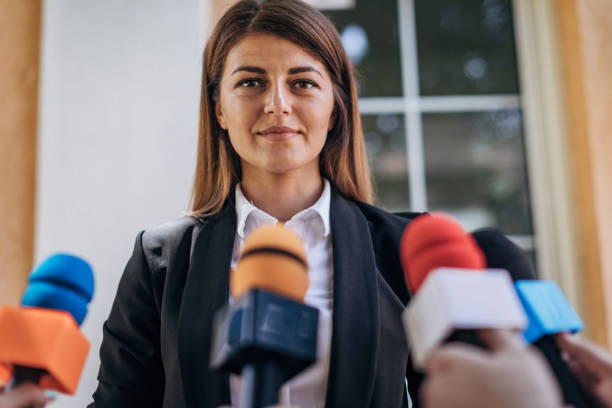 Politician speaking to reporters One woman, female politician talking into reporters microphones. spokesperson stock pictures, royalty-free photos & images