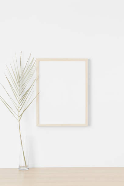 istock Wooden frame mockup on the wall with a palm leaf. 1331442124