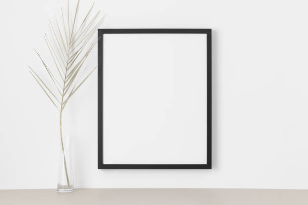 istock Black frame mockup on the wall with a palm leaf. 1331442134