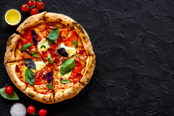 istock Cut into slices italian pizza with tomatoes cheese and basil 1331444933