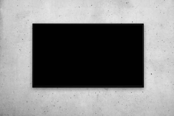 vista frontale di un moderno televisore a parete o cornice con schermo nero su una parete di cemento grigio - big screen tv foto e immagini stock