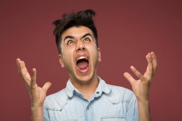 Middle-aged man scowls and shouts.