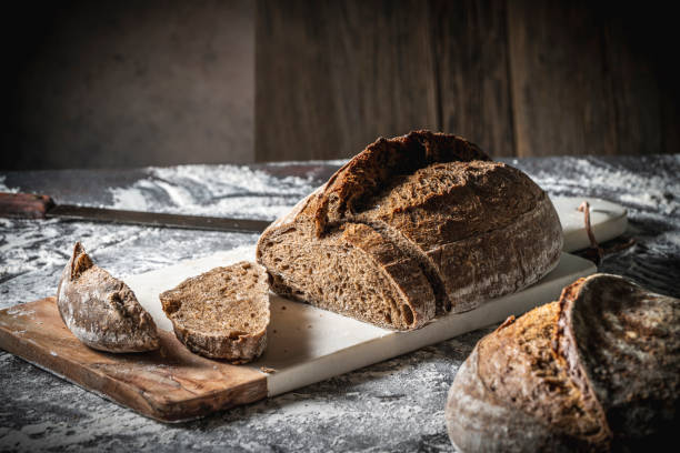 sauerteigbrot braun geschnittene scheiben vollkorn nach deutscher art auf schneidebrett - bauernbrot stock-fotos und bilder