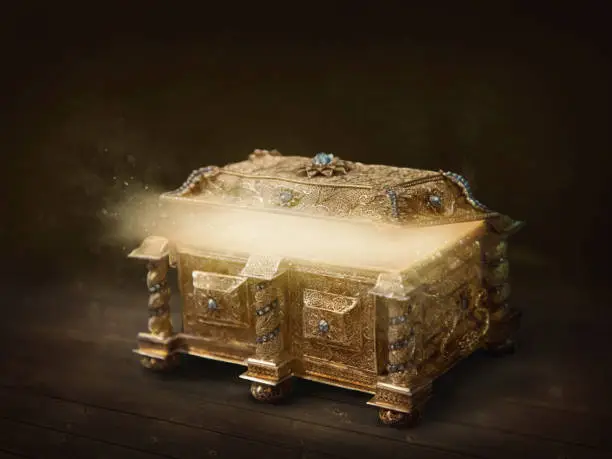 Golden open box with light on dark background