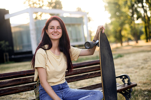 Young woman skateboarding in a city with a longboard. About 20 years old Caucasian redhead.