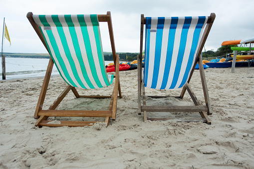 Typically British, empty deckchairs on empty beach on a dull miserable day in summer, not looking good for a great staycation.