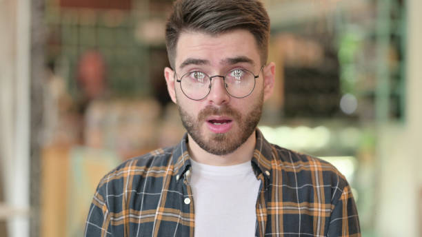 istock Upset Young Man Shocked by Results, Wondering 1331452781