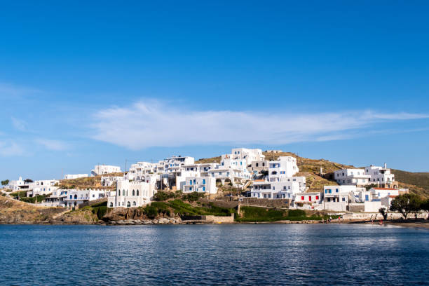 Landscape view of Loutra Village on Kythnos Island, Cyclades, Greece. Landscape view of Loutra Village on Kythnos Island, Cyclades, Greece. Traditional greek whitewashed houses with blue doors and window shutters in clear blue sky background, view from the sea. view into land stock pictures, royalty-free photos & images