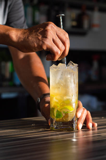 anónimo cultivado barman profesional africano agitando cóctel mojito helado agrio en el bar moderno - freshly squeezed fotografías e imágenes de stock