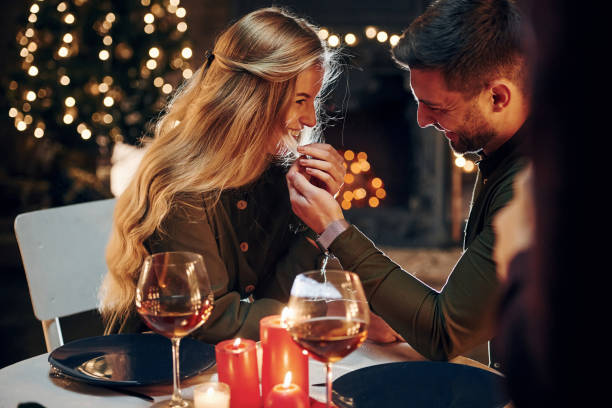 Side view. Young lovely couple have romantic dinner indoors together Side view. Young lovely couple have romantic dinner indoors together. boyfriend stock pictures, royalty-free photos & images