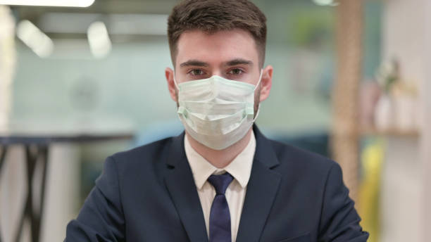 istock Young Businessman with Face Mask Looking at the Camera 1331469476