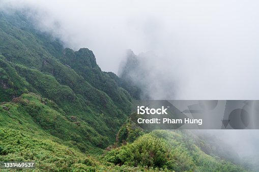 istock Clouds cover half of the mountain cliff 1331469537