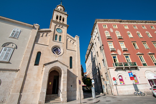 Church and Monastery of St Francis in Split, Croatia, with store names and logos in the background